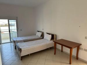 a room with two beds and a table at Apartaments Elvis Prela in Durrës