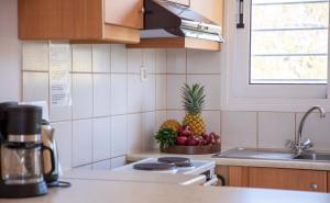 a kitchen with a pineapple and fruits on the counter at Stefanie Studios in Egina