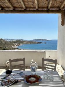 a table with a view of the ocean and a table and chairs at Blue and White Mykonos ap2 in Mikonos