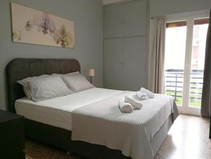 a bedroom with a bed with two towels on it at Sunny Living in Loutraki