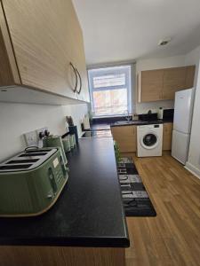 a kitchen with a black counter top in a kitchen at Glams luxury flat in Wolverhampton +15 photos