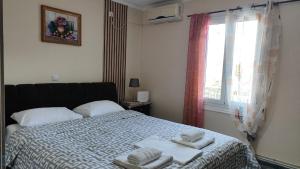 a bedroom with a bed with towels on it at Villa tusia in Vravrona