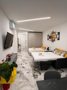 a hotel room with two beds and a couch at Aliss Appartamenti in Negrar