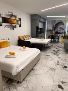a room with two beds and a living room at Aliss Appartamenti in Negrar