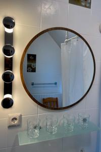 een badkamer met een spiegel en glazen op een plank bij Chez Lana in Berlijn +42 foto's