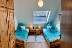 een kleine kamer met twee bedden en een raam bij Chez Lana in Berlijn