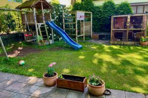 een achtertuin met een speeltuin met glijbaan en potplanten bij Chez Lana in Berlijn