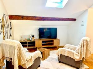 TV a/nebo společenská místnost v ubytování Hotel Les Rêveries du CLOS derrière St Jean Vignes &Spa