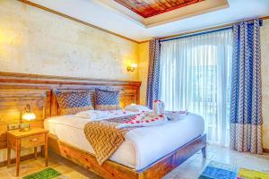 una camera da letto con un letto grande e una finestra di Unique Cappadocia Palace a Göreme