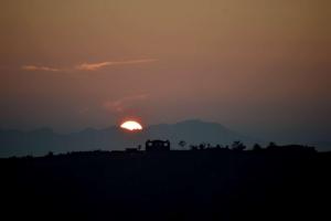 a sunset with the sun in the background at The Tatwa Hotel & Camping in Chakrāta