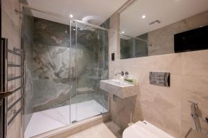 a bathroom with a shower and a toilet and a sink at Charles of Mayfair in London