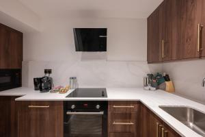 a kitchen with a sink and a stove top oven at Charles of Mayfair in London