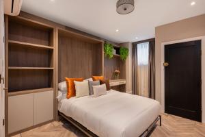 a bedroom with a large white bed and shelves at Charles of Mayfair in London