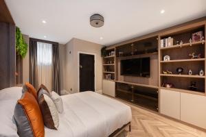 a bedroom with a large bed and a flat screen tv at Charles of Mayfair in London