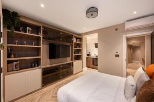 a bedroom with a large white bed and a flat screen tv at Charles of Mayfair in London