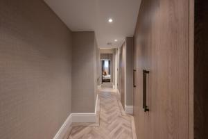 a hallway of a house with wooden walls and a door at Charles of Mayfair in London