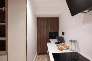 a small kitchen with a counter and a sink at Charles of Mayfair in London