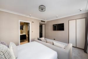 a bedroom with a white bed and a couch at Charles of Mayfair in London