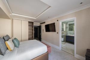 a bedroom with a white bed and a television at Charles of Mayfair in London