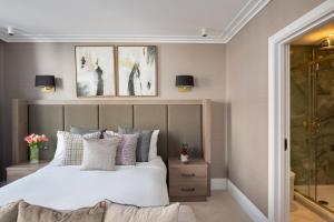 a bedroom with a large bed and two pictures on the wall at Charles of Mayfair in London
