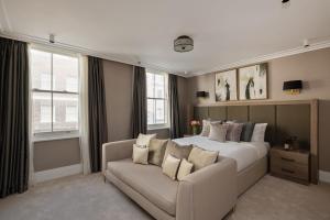 a bedroom with a large bed and a couch at Charles of Mayfair in London