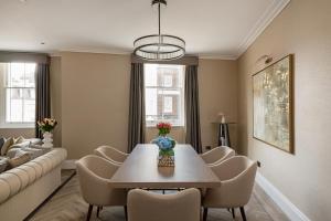 a living room with a table and chairs and a couch at Charles of Mayfair in London