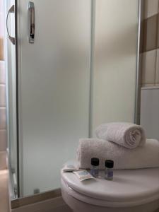 a bathroom with a toilet with towels and a shower at Ambe Apartments in Bitola +41 photos