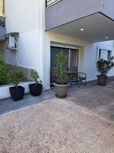 a patio with potted plants in front of a building at Good Holiday in Kallithea Halkidikis
