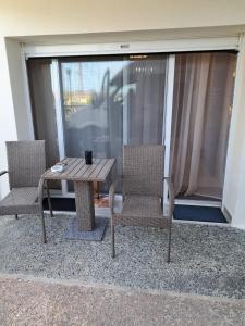 two chairs and a wooden table on a balcony at Good Holiday in Kallithea Halkidikis
