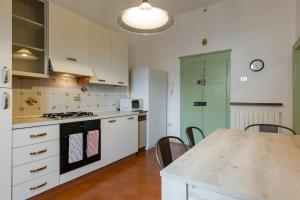 a kitchen with white cabinets and a table with chairs at Cosy apratment near PortaVescovo train station in Verona +6 photos