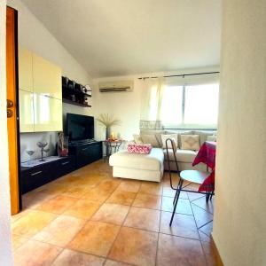 a living room with a couch and a table and chairs at DreamHouse Miramare in Budoni