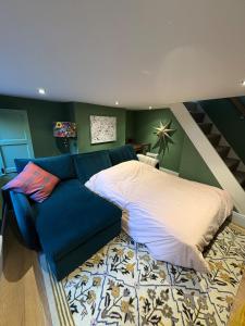 a bedroom with a bed and a blue couch at Cosy Cottage in Melbourne in Melbourne