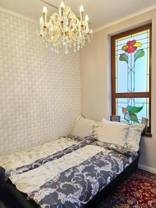 a bedroom with a bed with a chandelier and a window at Rumbach Terrace Apartment in Budapest +61 photos