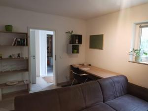 ein Wohnzimmer mit Sofa und Schreibtisch in der Unterkunft Dürr in Berlin
