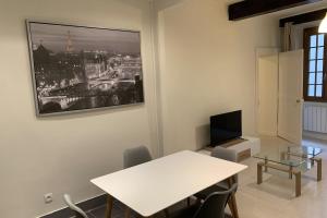 a dining room with a white table and a tv at Le Grand Sénat - 55m2 in Chambéry