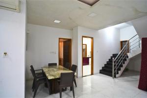 ein Esszimmer mit Tisch und Stühlen und einer Treppe in der Unterkunft Holiday Aapke Liye Bungalow no 8- 3 BHK in Khopoli