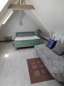 a attic room with two beds and a rug at Chambre sérénité in Moult