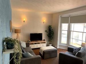 a living room with two couches and a flat screen tv at St James Dairy in Ilfracombe