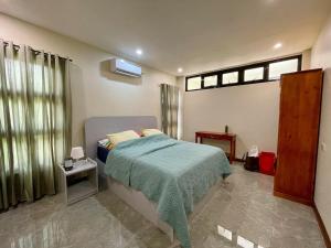 a bedroom with a bed with a blue blanket at JCPM Apartment Suite-3rd Floor in Santa Cruz