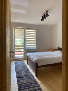 a bedroom with a bed and a window with blinds at Dvir in Skole