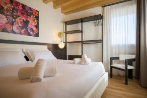 a hotel room with two beds and a chair at La Còrt Apartments - Number 2 in Manerba del Garda