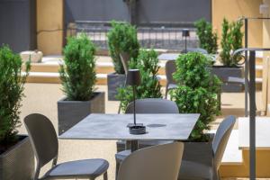 a table and chairs in a room with potted plants at La Còrt Apartments - Number 2 in Manerba del Garda +6 photos