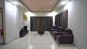 ein Wartezimmer mit Ledersesseln und einem TV in der Unterkunft Holiday Aapke Liye Bungalow no 8- 3 BHK in Khopoli