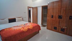 ein Schlafzimmer mit einem Bett und einem Holzschrank in der Unterkunft Holiday Aapke Liye Bungalow no 8- 3 BHK in Khopoli + 30 Fotos