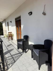 a patio with chairs and tables on a white wall at G&N apartment in Agropoli
