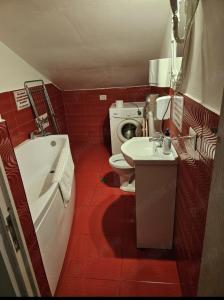 a bathroom with a toilet and a tub and a sink at Răsfăț cazare in Focşani