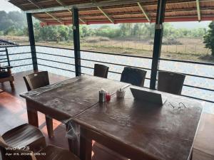 a wooden table with a laptop on top of it at Jolly Homestay in Jog Falls +14 photos