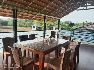 a wooden table and chairs on a patio at Jolly Homestay in Jog Falls