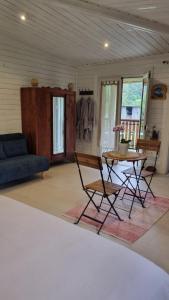 a living room with a table and chairs and a couch at Le Palmiste Enchanté in La Plaine des Palmistes