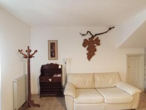 a living room with a white couch and a branch on the wall at Appartamento Taverna Gattolini Venzone in Venzone +43 photos